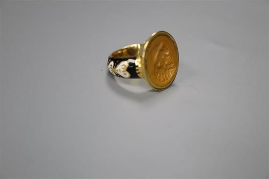 An antique yellow metal, black and white enamel and intaglio hardstone set signet ring, size K, gross 6.1 grams.